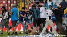 Fans clash during a Mexican soccer league match between the host Queretaro and Atlas from Guadalajara, at the Corregidora stadium, in Queretaro, Mexico, Saturday, March 5, 2022. Multiple people were injured during the brawl, including two critically. (AP Photo/Sergio Gonzalez)