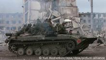 10/02/2000 A Russian tank with soldiers sitting ontop of it passes by destroyed buildings in the Chechen capital Grozny on Wednesday, 09 February 2000. Russian warplanes on Wednesday, 09 February 2000, for the first time dropped 1,5-tonne bombs on the southern mountains region of Chechnya where rebels were setting up a new power base. dpa (Digitale Fotografie) +++ dpa-Bildfunk +++