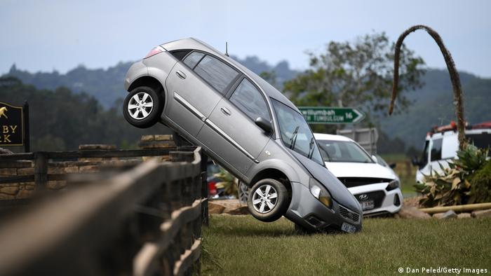 A car rests on a fence after it was carried there by floodwater in New South Wales