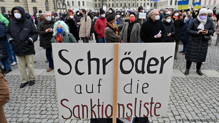demonstranten in Duitsland die oproepen om Schröder op de sanctielijst van Russische oligarchen te plaatsen