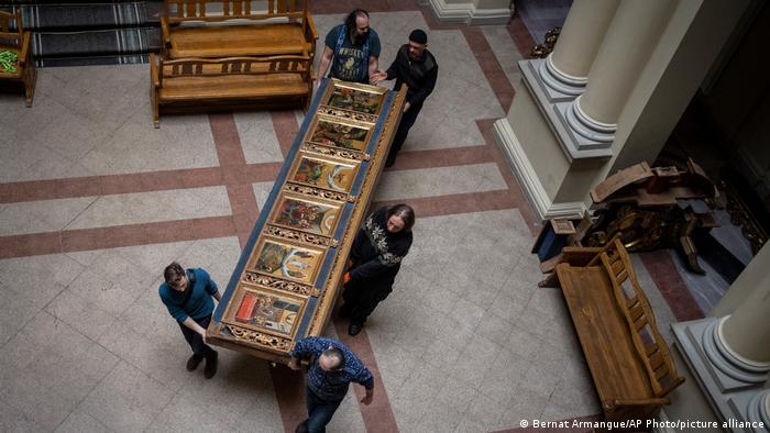 Fünf Menschen tragen eine große Ikonendarstellung durch das Nationalmuseum in Lwiw