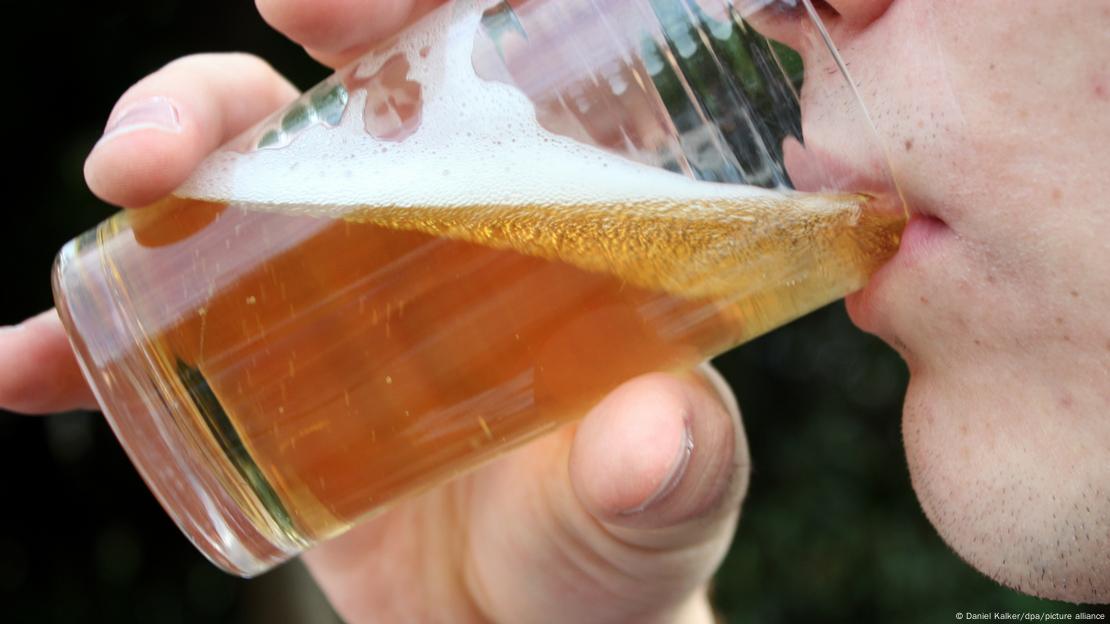 Un joven bebe una cerveza.