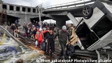 People cross an improvised path under a destroyed bridge while fleeing the town of Irpin close to Kyiv, Ukraine, Monday, March 7, 2022. (AP Photo/Efrem Lukatsky)
