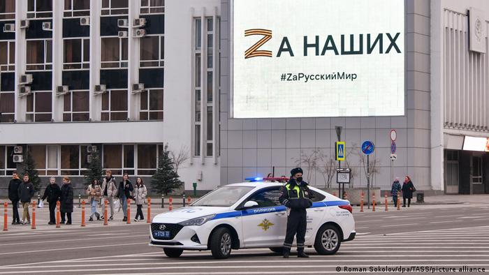En el centro de Krasnodar se ve a un agente de la policía de tráfico; al fondo, un cartel con la leyenda Por nuestro pueblo y la letra Z que expresa el apoyo a la guerra en Ucrania.
