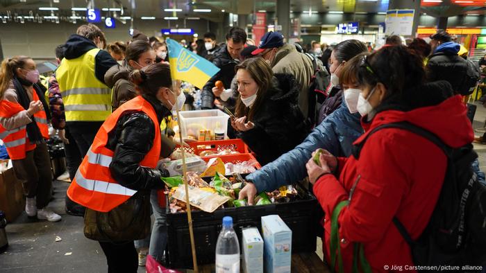 Ayudantes dando comida a los refugiados en la estación de tren de Berlín en marzo de 2022