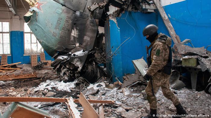 A Ukrainian soldier walks past the tail fin of a Russian bomber in a damaged building in Kharkiv, March 8, 2022