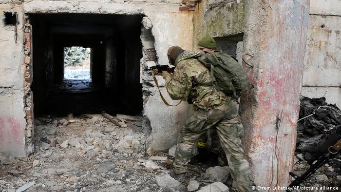 Escena de guerra. soldados bielorrusos con armas entre ruinas de un edificio.