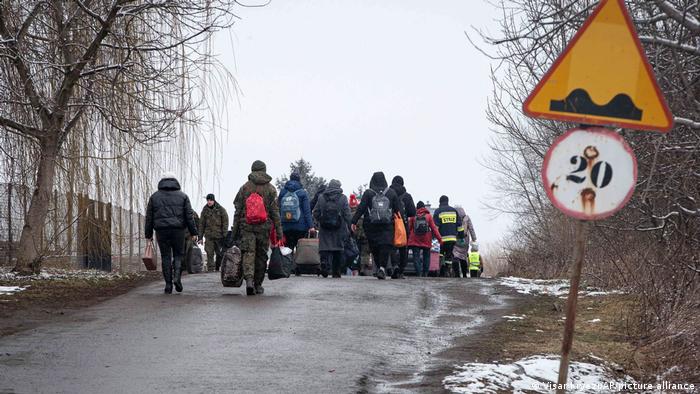Personas huyen de Ucrania en dirección a una estación de tren en la frontera con Medyka, Polonia