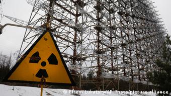 A Soviet-era top secret object Duga, an over-the-horizon radar system once used as part of the Soviet missile defense early-warning radar network, seen behind a radioactivity sign in Chernobyl