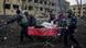 Ukrainian emergency employees and volunteers carry an injured pregnant woman from the damaged by shelling maternity hospital in Mariupol, Ukraine