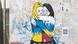Street art in Rome shows two women hugging and crying, painted in the colors of the flags of Ukraine and Russia Street art in Rome shows two women hugging and crying, painted in the colors of the flags of Ukraine and Russia