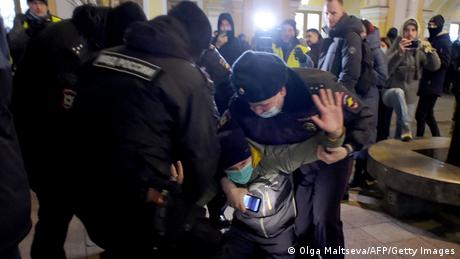Rosyjscy policjanci szarpiący się z demonstrantem