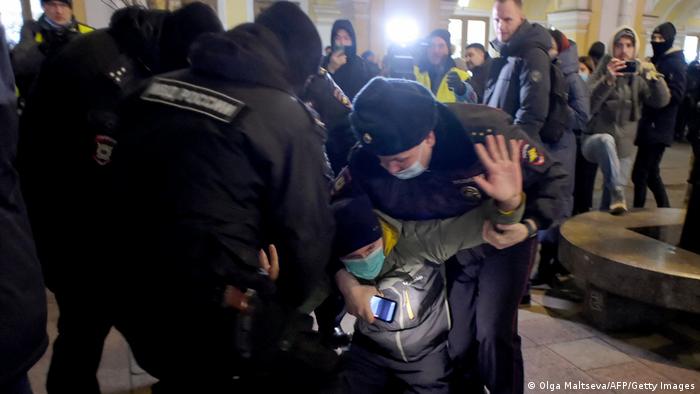 Police officers detain a man during a protest against Russia's invasion of Ukraine in central St. Petersburg