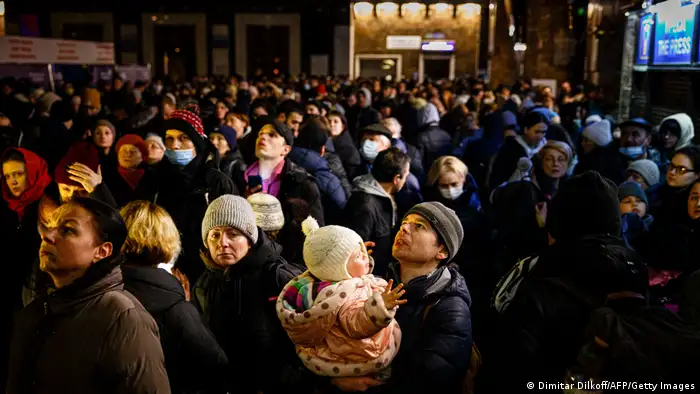 People wait to board an evacuation train at Kyiv central train station