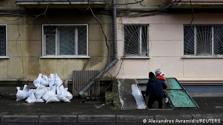 Rodzic schodzący z dzieckiem do schronu pod budynkiem