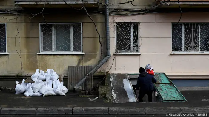 Viktor Anatolyevich, 27, enters an underground shelter in Odesa with his 3-year-old daughter on March 9.