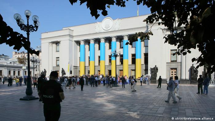Gebäude des ukrainischen Parlamentes mit Nationalfarben Blau-Gelb an den Säulen des Portals und Menschen auf dem Platz davor, Archiv