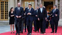 French President Emmanuel Macron, center, speaks with European Council President Charles Michel, center left, as they walk to a group photo at an EU summit at the Chateau de Versailles, in Versailles, west of Paris, Thursday, March 10, 2022. European Union leaders on Thursday will focus on how to help Ukraine in its war with Russia, but the measures discussed are expected to stop short of fulfilling the country's hopes it can soon join the bloc. (AP Photo/Michel Euler)