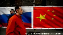 01.03.2019, Serbien, Belgrad: Ein Mann geht an einem Banner mit den Nationalflaggen von Russland und China vorbei. Russland und China unterstützen Serbiens Weigerung, den Kosovo als unabhängige Republik anzuerkennen. Foto: Darko Vojinovic/AP/dpa +++ dpa-Bildfunk +++