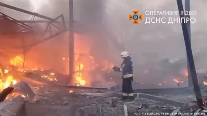 A firefighter stands in front of a burning building in Dnipro