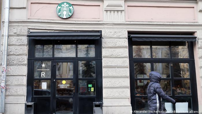 A woman walks past a Starbucks coffee shop in Moscow
