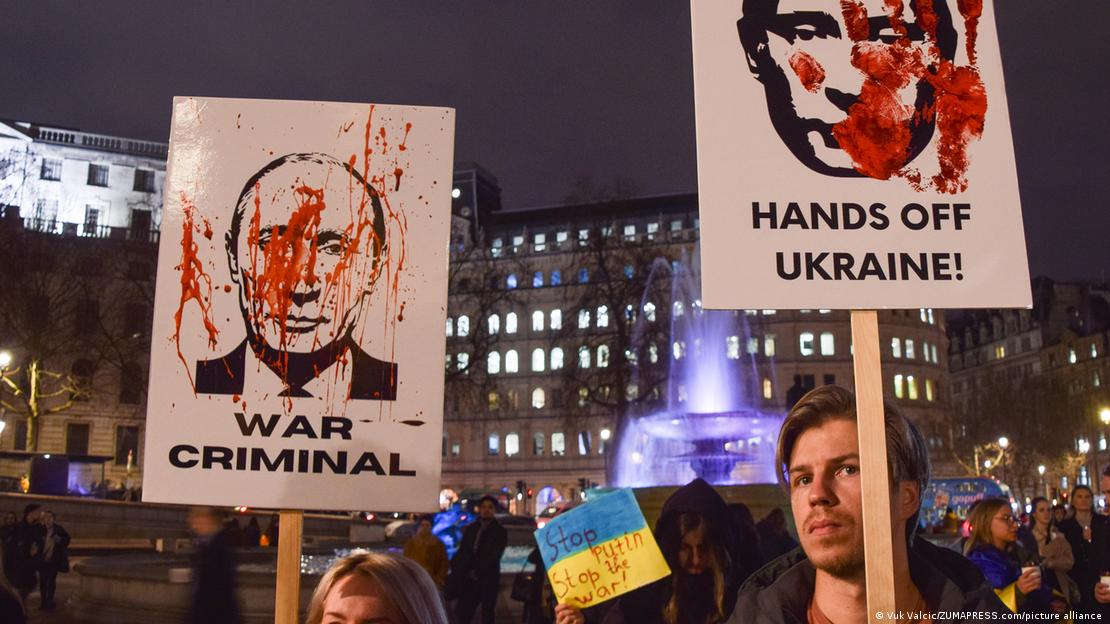 Cartazes com o rosto de Putin e dizeres: 