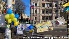 09.03.2022, Lettland, Riga: Luftballons in den Farben der offiziellen Nationalflagge der Ukraine, sowie Plakate sind auf dem Platz vor der russischen Botschaft in Riga aufgestellt. Vor der Botschaft finden täglich Proteste und Kundgebungen statt. Foto: Alexander Welscher/dpa +++ dpa-Bildfunk +++