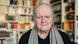 Wolfgang Rihm schmunzelt in die Kamera, hinter ihm Bücherregale Wolfgang Rihm schmunzelt in die Kamera, hinter ihm Bücherregale