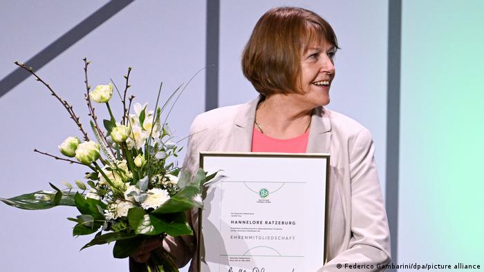 Hannelore Ratzeburg smiling and holding flowers after being honored at the 44th Ordinary DFB-Bundestag at the World Conference Center Bonn