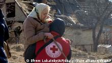 11.03.2022 Ein Mitarbeiter des Roten Kreuzes trägt eine ältere Frau während der Evakuierung von Irpin nordwestlich von Kiew. +++ dpa-Bildfunk +++