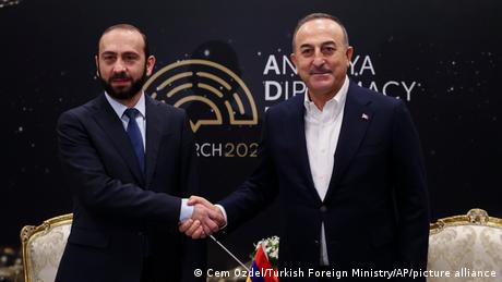 Armenian Foreign Minister Ararat Mirzoyan (L) shakes hands with his Turkish counterpart Mevlut Cavusoglu on the sidelines of a forum in Antalya