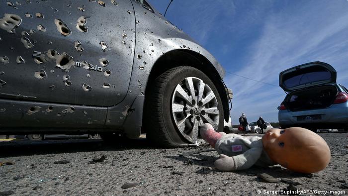 A child's abandoned doll next to a car riddled with bullets in Irpin, north of Kyiv