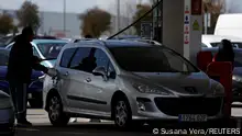 A driver refuels a car at a low cost gas station, while other drivers queue, as gasoline prices keep rising, in Getafe, Spain, March 12, 2022. REUTERS/Susana Vera