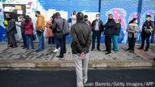 People queue in front of a polling station in Bogota on March 13, 2022. - Colombians began voting this Sunday to elect a new Congress and define the list of candidates that will face Senator and former guerrilla Gustavo Petro in the presidential elections on May 29, in which the left is the favorite for the first time. (Photo by Juan BARRETO / AFP) (Photo by JUAN BARRETO/AFP via Getty Images)