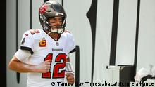 Tom Brady wearing a Buccaneers shirt and protective headgear