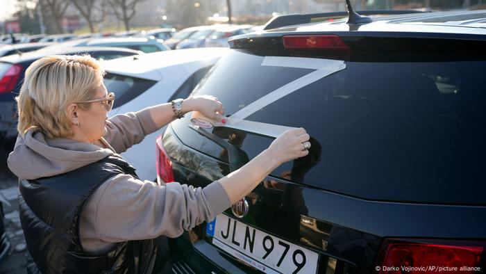 Una mujer dibuja con cinta una Z en su vehículo durante una manifestación prorrusa en Belgrado el pasado 13 de marzo.