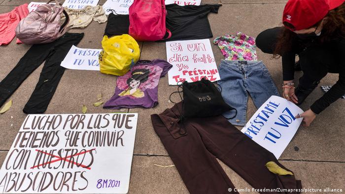 Ropas de víctimas de feminicidio y carteles yacen en el piso de una calle en San Salvador a manera de protesta contra la violencia.