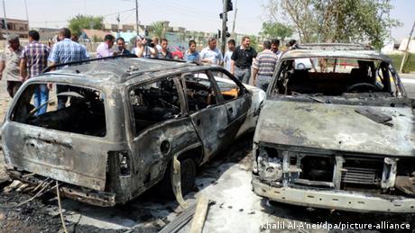 Iraqi men inspect the scene of a car bomb attack near a government building in Kirkuk, northern Iraq.