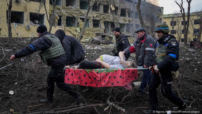 Une femme enceinte blessée est portée par des employés d'urgence et des bénévoles ukrainiens 