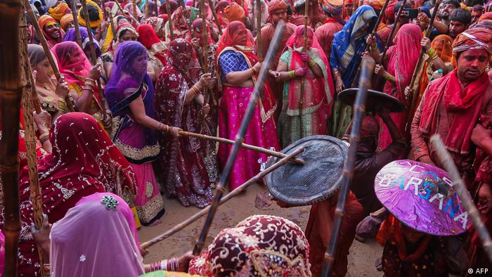 Women hit revellers with sticks as a traditional practice during the Lathmar Holi celebrations, in India's Uttar Pradesh state on March 12, 2022
