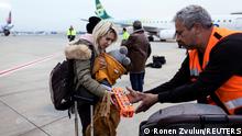 An Israeli man helps a Ukranian refugee as she arrives from Romania after Russia's invasion of Ukraine, at Ben Gurion international airport in Lod near Tel Aviv, Israel, March 8, 2022. REUTERS/Ronen Zvulun
