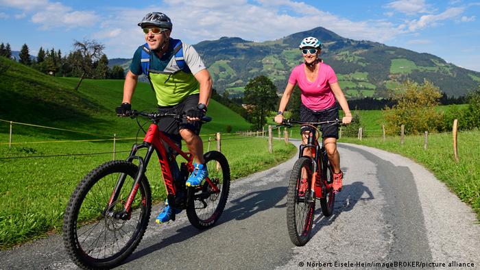Couple comes up the mountain with e-mountain bikes and smiles