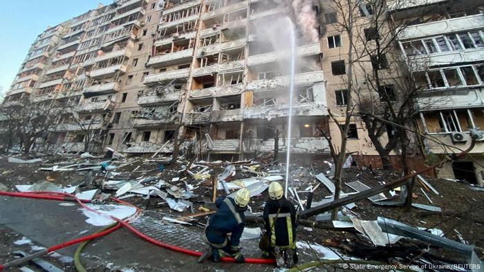 Rescuers work next to a residential building damaged by shelling, as Russia's attack on Ukraine continues, in Kyiv
