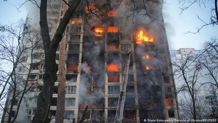 Rescuers work next to a residential building damaged by shelling, as Russia's attack on Ukraine continues.