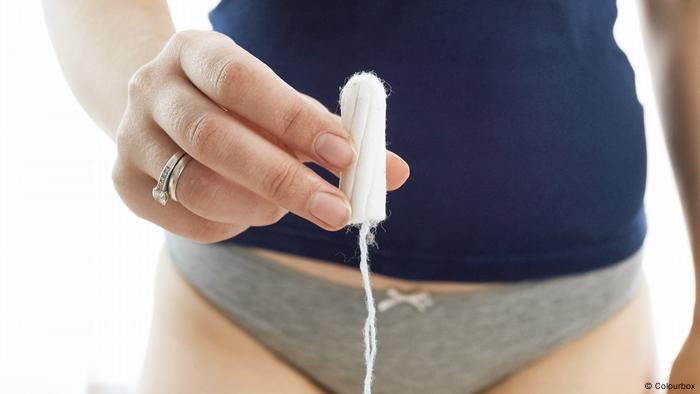 A woman holds up a tampon