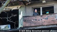 Eine Bewohnerin des Wohnhauses, das von einem russischen Luftangriff getroffen wurde, steht auf ihrem Balkon mit der ukrainischen Flagge. Ein russischer Luftangriff traf einen Wohnkomplex im Wohnviertel Obolon, nördlich des Stadtzentrums von Kiew. Es gab mindestens einen Toten und 12 Verletzte. Das ukrainische Militär und Freiwillige halfen bei den Aufräumarbeiten. (Wiederholung mit verändertem Bildausschnitt) +++ dpa-Bildfunk +++