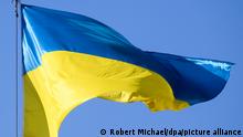 Eine Fahne der Ukraine weht als Zeichen der Solidarität mit den Menschen im Krieg vor dem Rathaus. +++ dpa-Bildfunk +++