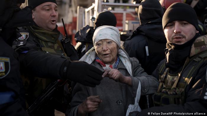 Polizisten betreuen eine ältere Bewohnerin von Kiew, nachdem sie aus ihrer beschossenen Wohnung gerettet werden konnte