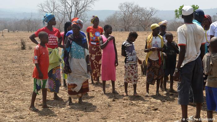 Residentes de la presa de Souapiti, Guinea, en un campo seco en marzo de 2020.