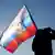 Ukraine-Krieg l Serbien, Mann hält russische Fahne in Belgrad